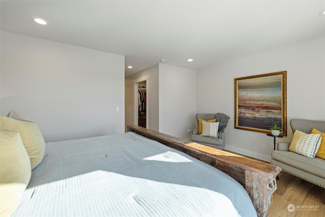 bedroom with a closet, hardwood / wood-style floors, and a walk in closet