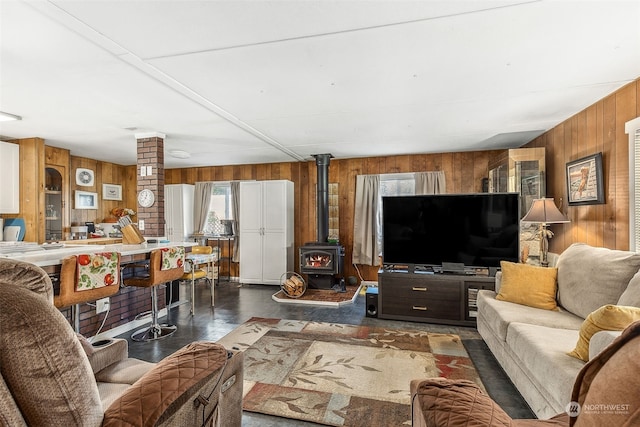 living room with wood walls and a wood stove