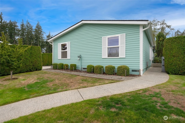 view of side of home with a yard