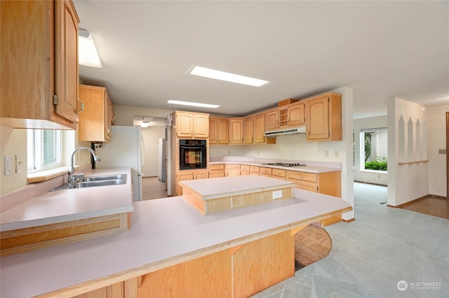 kitchen with sink, kitchen peninsula, black oven, light colored carpet, and a kitchen bar