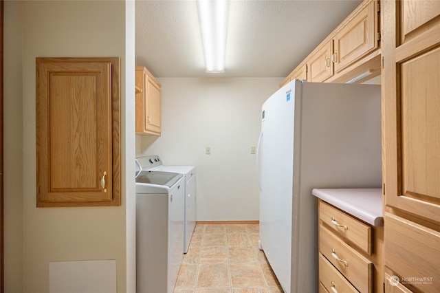 laundry area featuring a textured ceiling, separate washer and dryer, light tile patterned floors, and cabinets