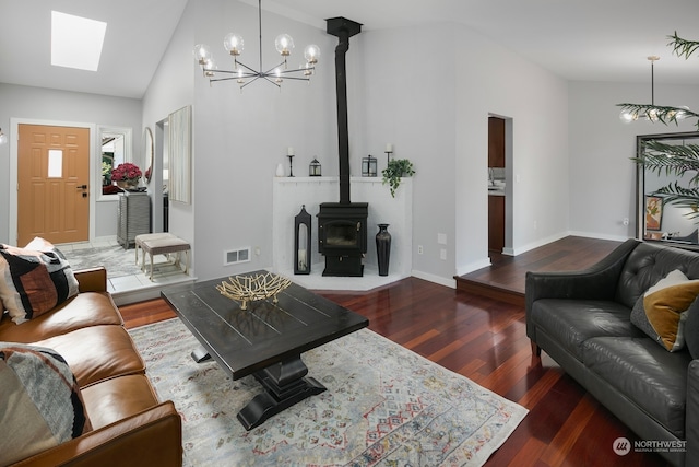 living room featuring an inviting chandelier, a wood stove, high vaulted ceiling, and dark hardwood / wood-style flooring