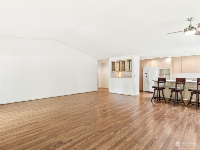 living room featuring lofted ceiling, ceiling fan, and light hardwood / wood-style flooring