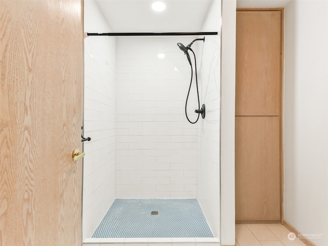 bathroom featuring a tile shower and tile patterned flooring