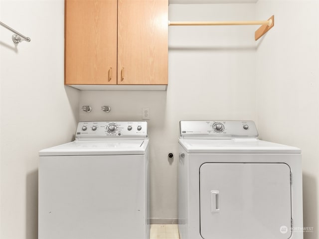 laundry room featuring washer and clothes dryer and cabinets