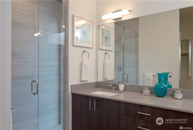 bathroom featuring vanity and an enclosed shower