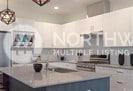 kitchen featuring hanging light fixtures, blue cabinetry, white cabinets, and range