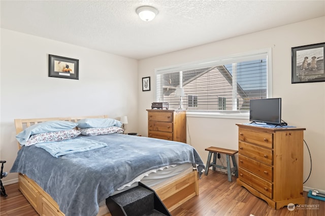 bedroom with hardwood / wood-style flooring and a textured ceiling