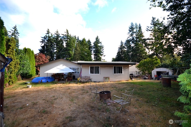 back of house with a fire pit