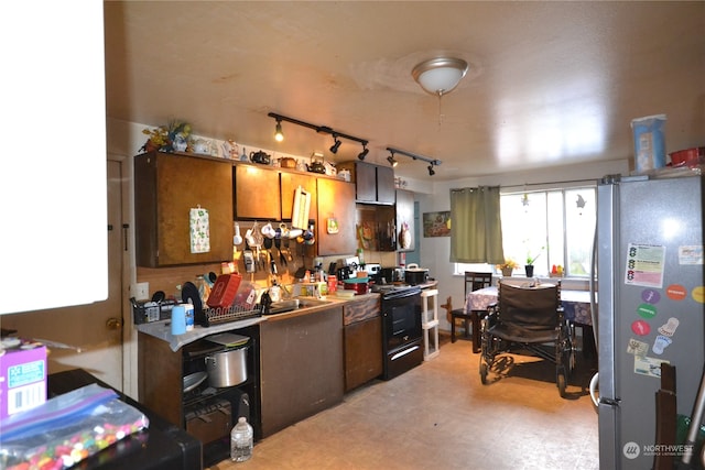 kitchen with black / electric stove, stainless steel fridge, and sink