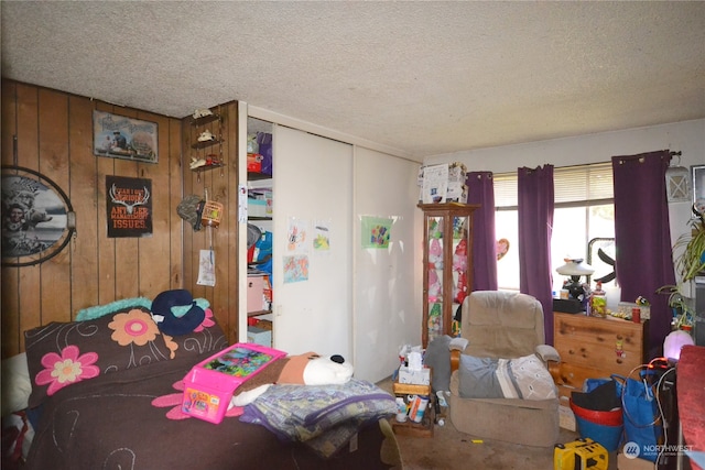 bedroom with a textured ceiling and wooden walls