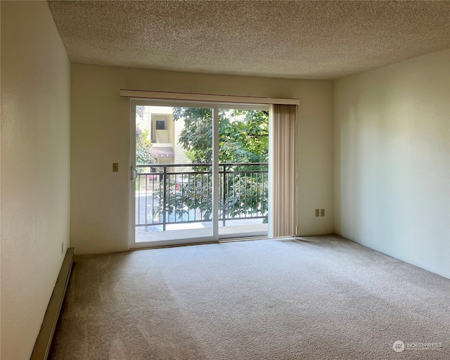 carpeted empty room featuring a textured ceiling