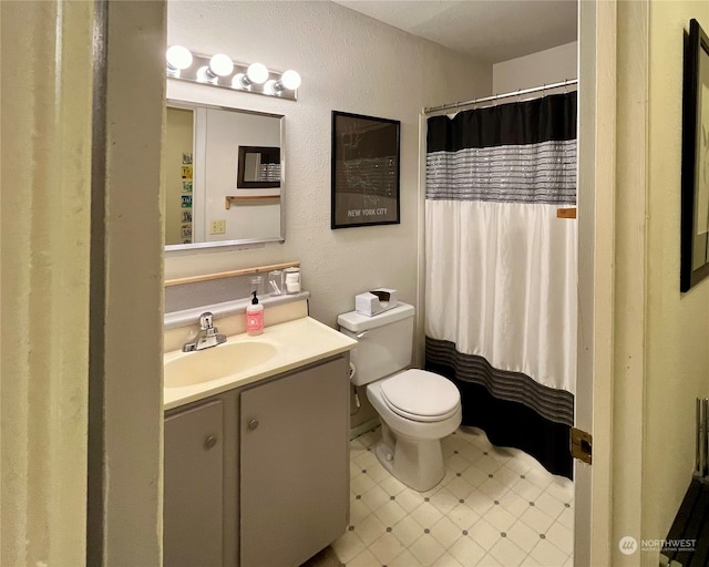 bathroom featuring toilet, a shower with curtain, vanity, and tile patterned flooring