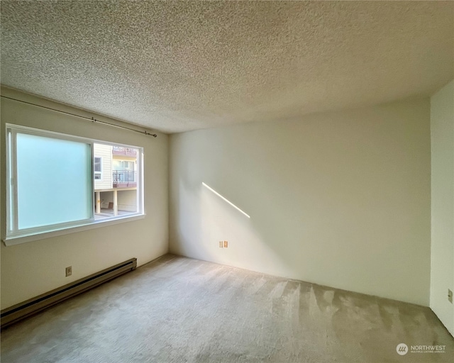 carpeted empty room featuring a baseboard radiator and a textured ceiling