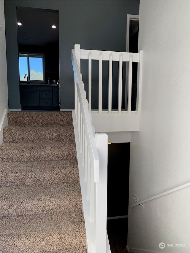 staircase with sink and carpet flooring