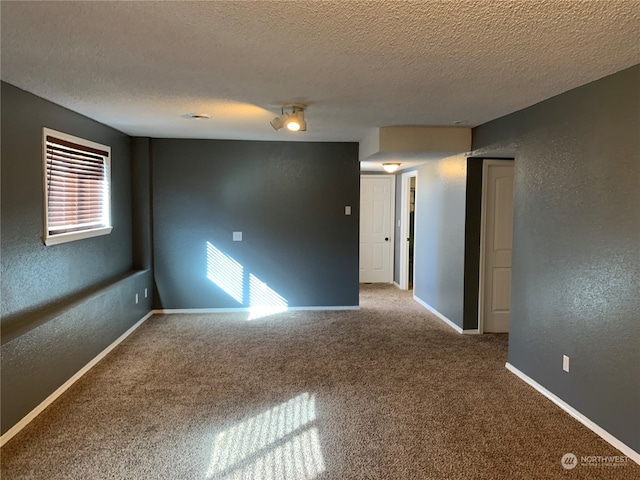 carpeted spare room with a textured ceiling