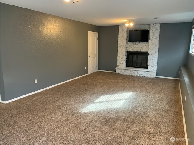 unfurnished living room with carpet and a fireplace