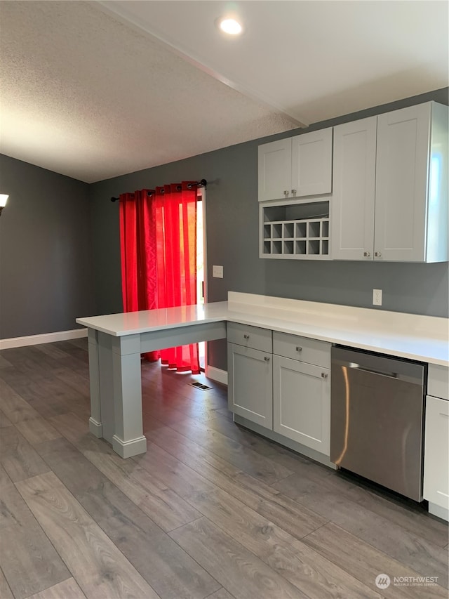 kitchen featuring dishwasher, light hardwood / wood-style flooring, kitchen peninsula, and a kitchen breakfast bar