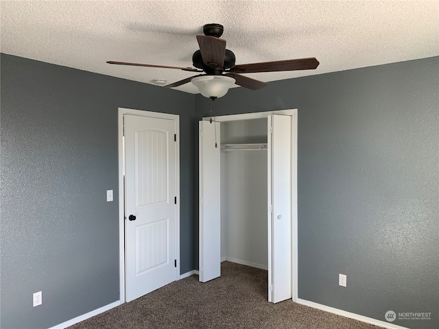 unfurnished bedroom with dark carpet, a closet, ceiling fan, and a textured ceiling