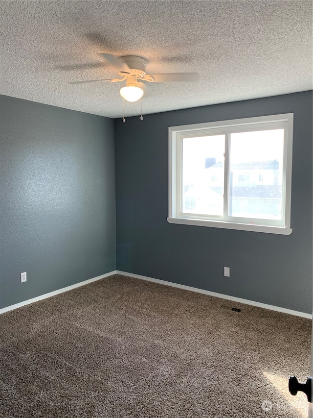 carpeted empty room with a textured ceiling and ceiling fan