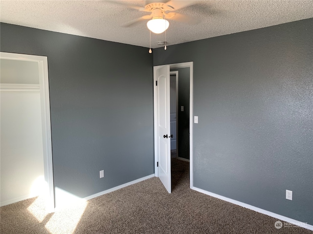 unfurnished bedroom with a textured ceiling, carpet flooring, ceiling fan, and a closet