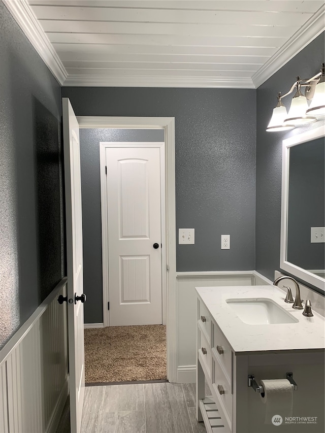 bathroom featuring crown molding, vanity, and hardwood / wood-style floors