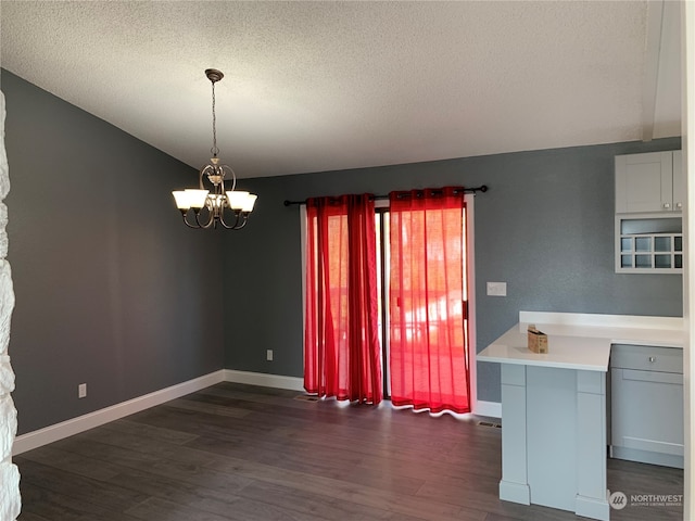 interior space with a chandelier, a textured ceiling, and dark hardwood / wood-style flooring