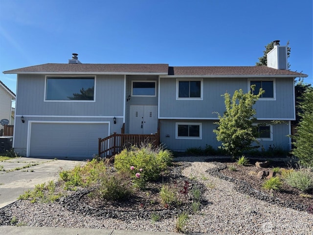 812 W Edgewater Ln, Moses Lake, WA 98837 - bi-level home featuring a chimney, an attached garage, and driveway