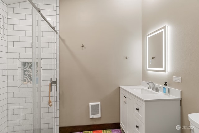 bathroom featuring vanity, heating unit, a shower with shower door, and toilet