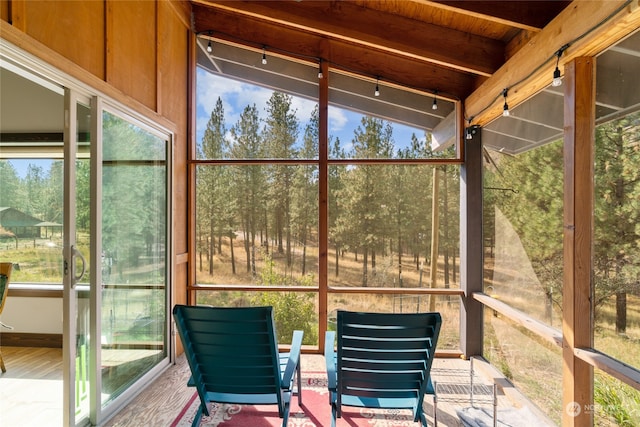 unfurnished sunroom featuring vaulted ceiling