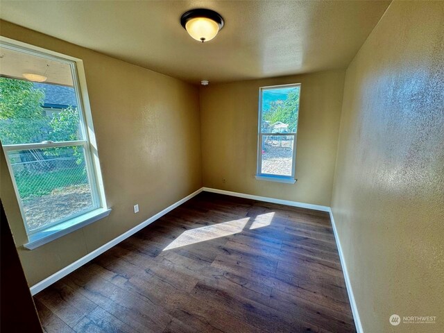 empty room featuring wood finished floors and baseboards