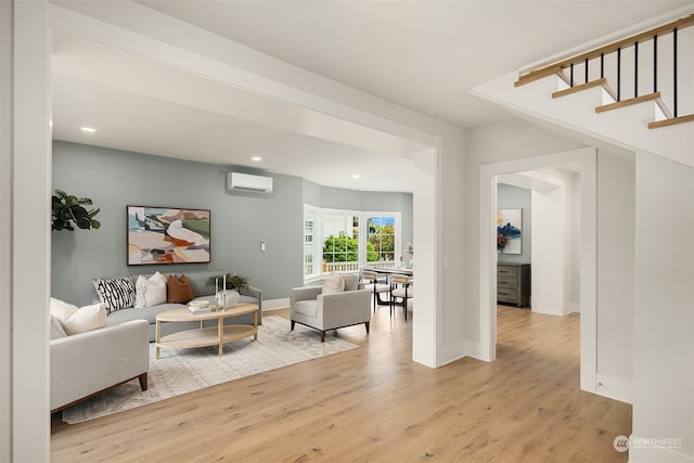 living room featuring light wood-type flooring and a wall mounted air conditioner