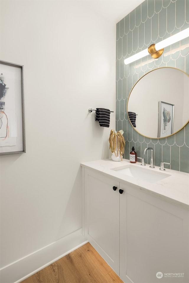 bathroom with decorative backsplash, hardwood / wood-style floors, and vanity