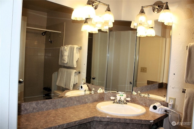 bathroom with an inviting chandelier, walk in shower, and vanity