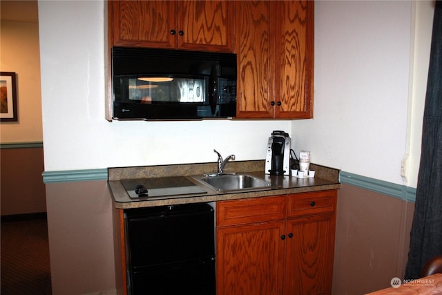 kitchen featuring brown cabinets, black microwave, and a sink