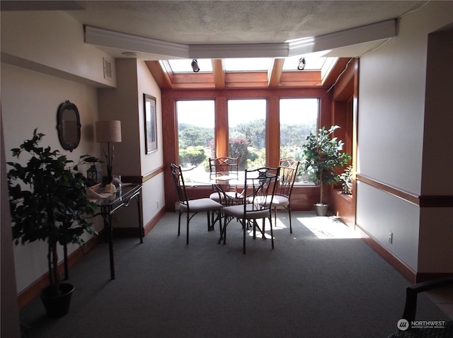 dining space featuring carpet, baseboards, visible vents, and a skylight