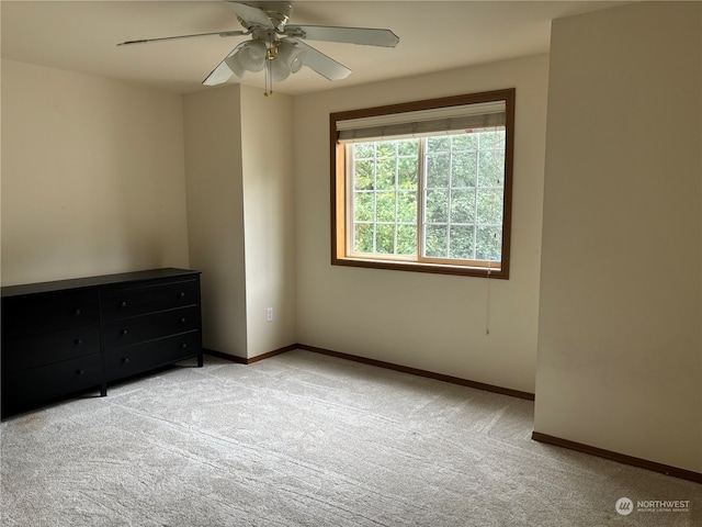 spare room featuring light carpet and ceiling fan