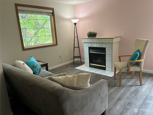 living room with a tiled fireplace and light hardwood / wood-style floors