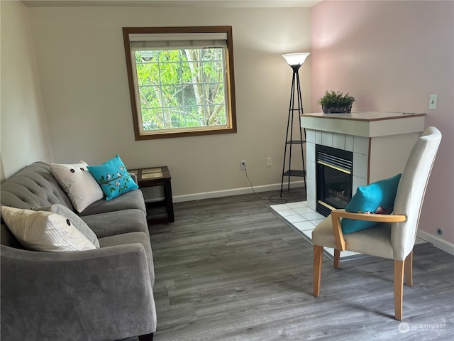 living room featuring a tile fireplace and hardwood / wood-style floors