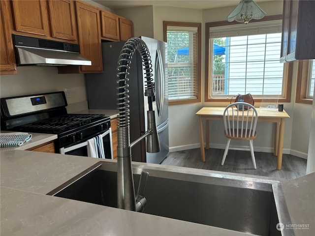 kitchen with gas stove, dark hardwood / wood-style flooring, and built in desk