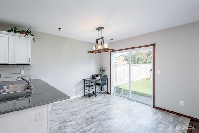 unfurnished dining area featuring an inviting chandelier and sink