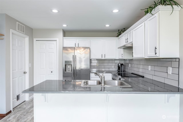 kitchen with sink, white cabinetry, kitchen peninsula, black electric cooktop, and stainless steel fridge