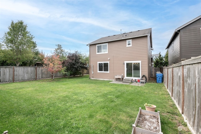 rear view of property featuring a patio and a yard