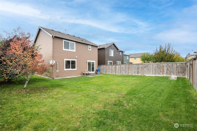 rear view of house featuring a yard and a patio