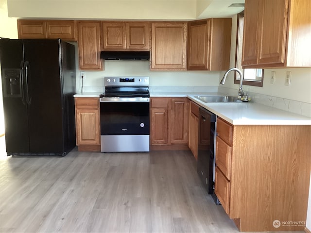 kitchen featuring light wood-type flooring, sink, and black appliances