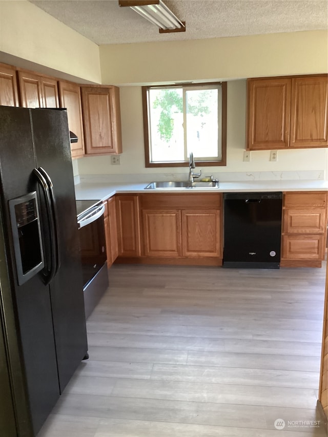 kitchen with fridge with ice dispenser, stainless steel range, light hardwood / wood-style flooring, sink, and dishwasher