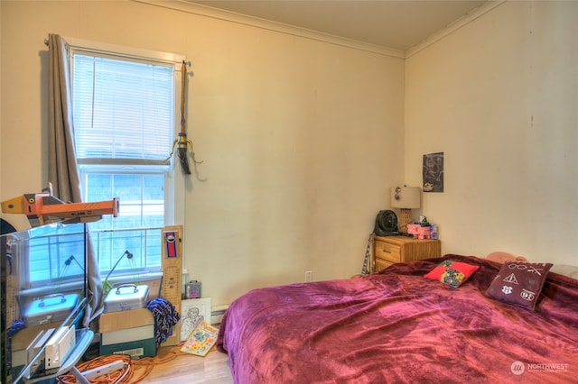 bedroom with multiple windows, crown molding, and hardwood / wood-style floors