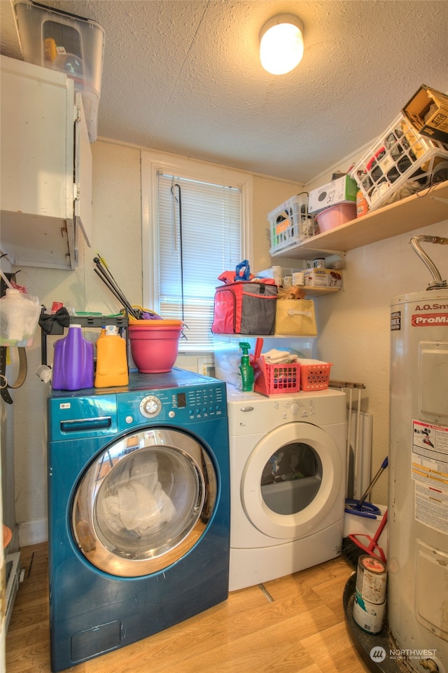 laundry room with a textured ceiling, separate washer and dryer, light hardwood / wood-style flooring, and electric water heater