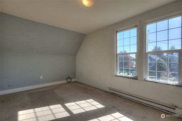 additional living space with light carpet, a baseboard radiator, and lofted ceiling