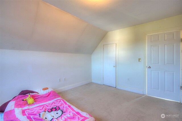 bedroom featuring lofted ceiling and light colored carpet